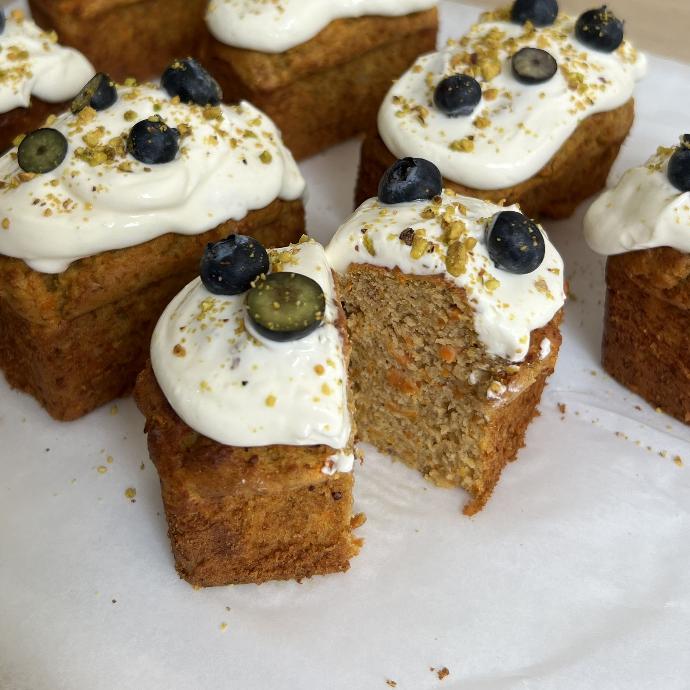 Porciones de carrot cake sin azúcar decoradas con crema y arándanos frescos.